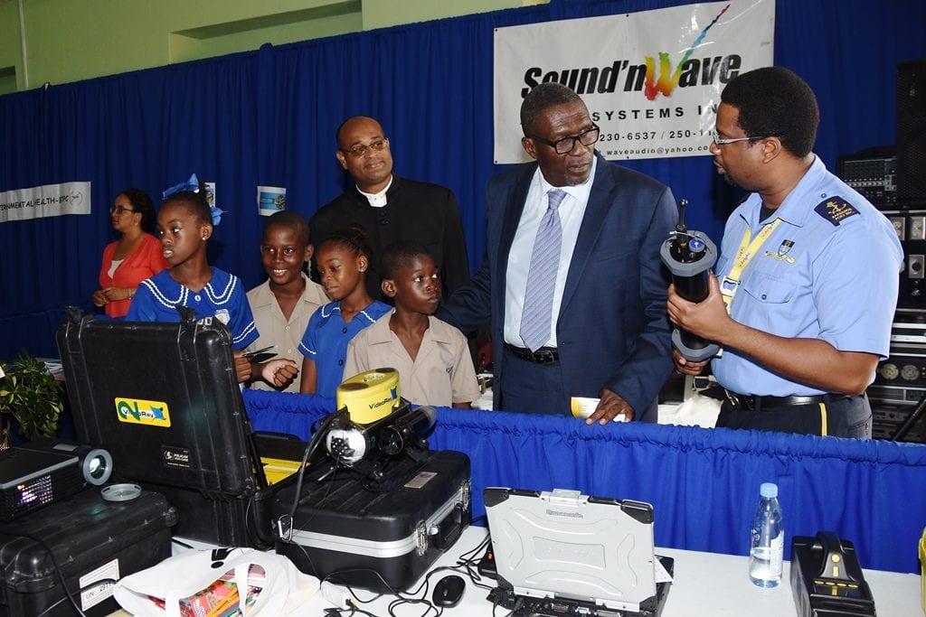 Senator Harry Husbands; Minister of State in the Office of the Prime Minister, Senator Patrick Todd and Wesley Hall Junior students visiting the display both of the Barbados Port Authority at today's Career Showcase. (C.Pitt/BGIS)