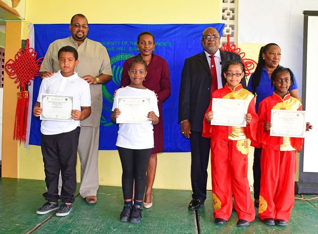 (Back row l-r) Principal of Stephen's Primary, Colin Cumberbatch; Permanent Secretary, June Chandler; Registrar Kenneth Walters and UWI Representative, Gail Hall pose with students (l-r) Tyler Forde; Kayshaunte Scantlebury; Kilia Francis and Savannah Small following their graduation from Level 1 Mandarin course. (UWI)